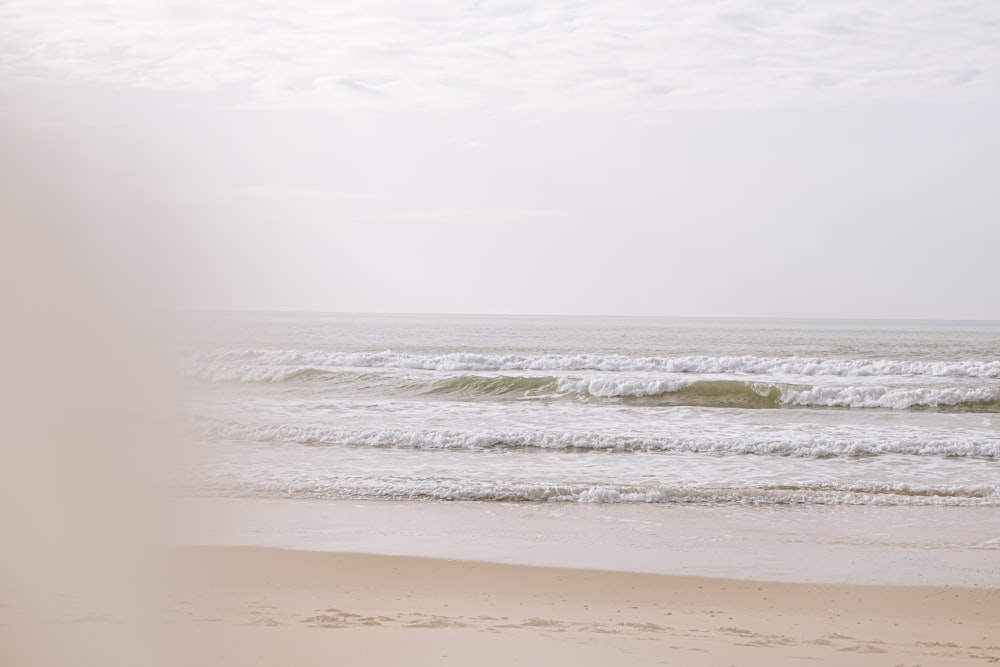 ocean waves crashing on shore during daytime