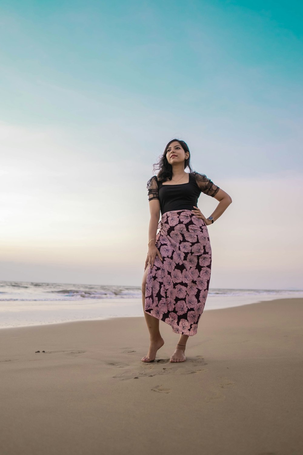 a woman standing on top of a sandy beach