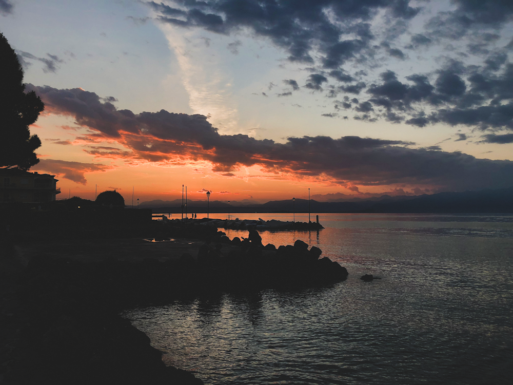 silhouette of people on dock during sunset