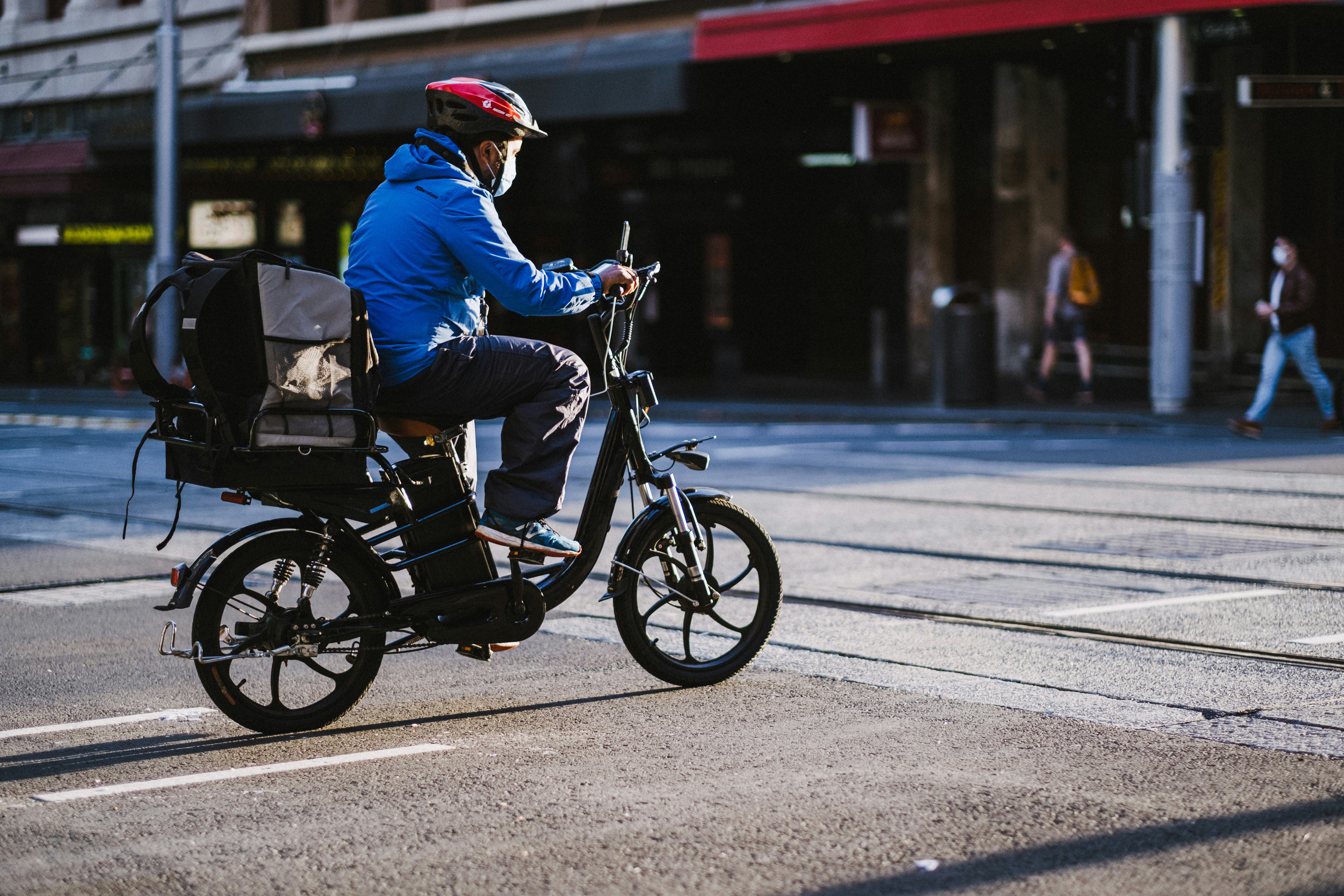 man in blue jacket riding on black motorcycle during daytime