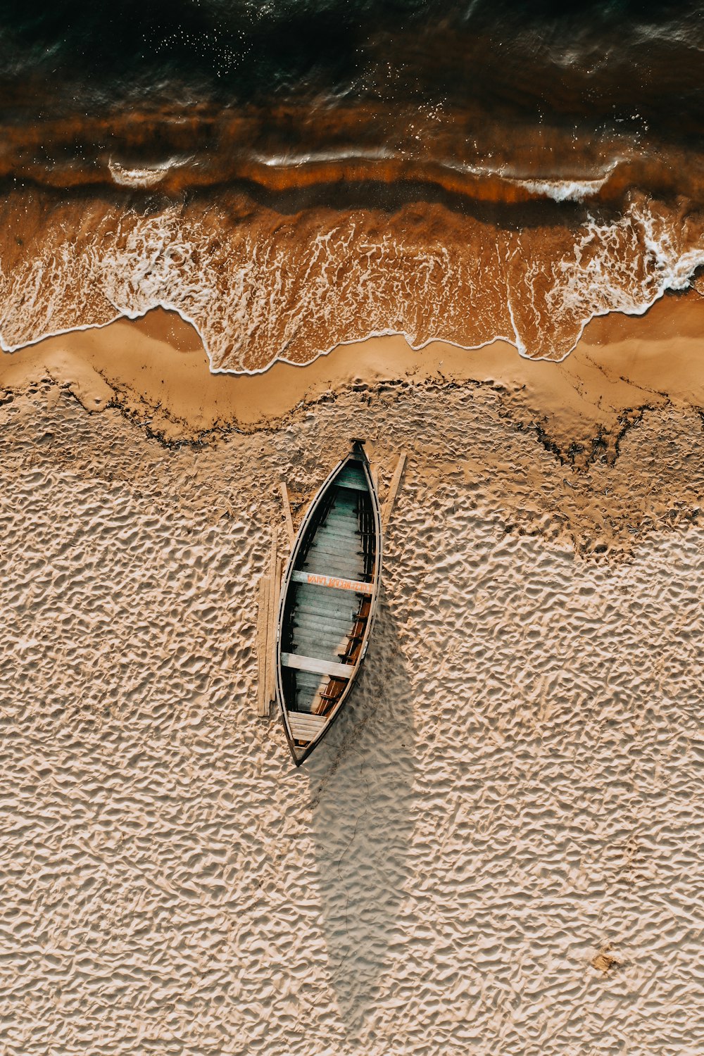 茶色の砂浜に茶色と白のボート