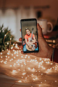 Close-up of hands holding a smartphone displaying a beautifully crafted personalized song video.