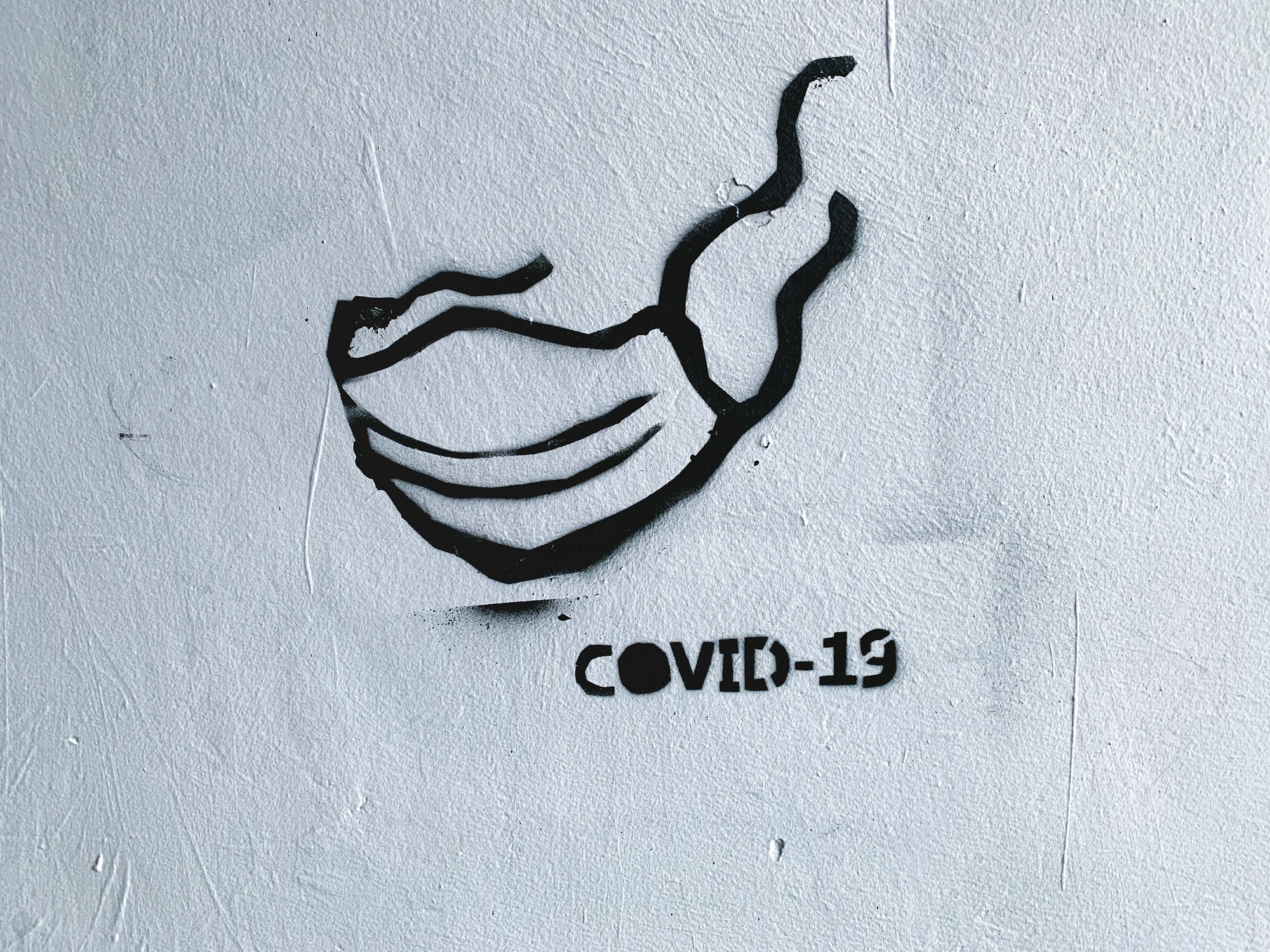 Street art - graffiti with facial mask on the wall during the current Coronavirus (COVID-19) pandemic in Warsaw, Poland