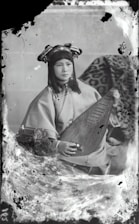A vintage painting depicting a classical Hindustani musician playing the sitar in a serene temple setting.