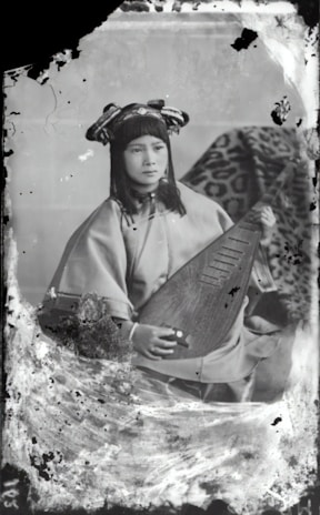 A vintage painting depicting a classical Hindustani musician playing the sitar in a serene temple setting.