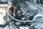 A detailed view of a car engine with visible components including spark plugs, engine cover, various hoses, and wires. The engine appears clean and well-maintained, indicating it might be from a high-performance vehicle.