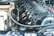 A detailed view of a car engine with visible components including spark plugs, engine cover, various hoses, and wires. The engine appears clean and well-maintained, indicating it might be from a high-performance vehicle.