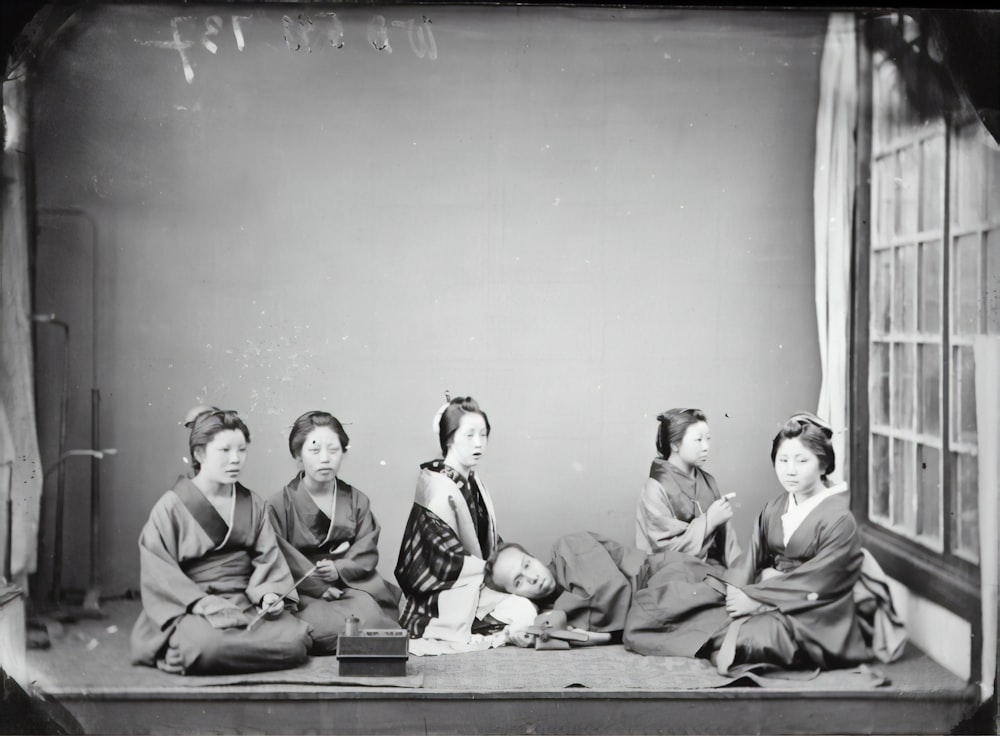 grayscale photo of men sitting on bench