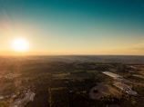 A sweeping drone shot over the rolling hills and industrial skyline of Northwest England at sunset.
