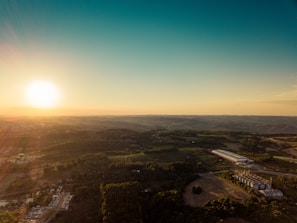 A sweeping drone shot over the rolling hills and industrial skyline of Northwest England at sunset.