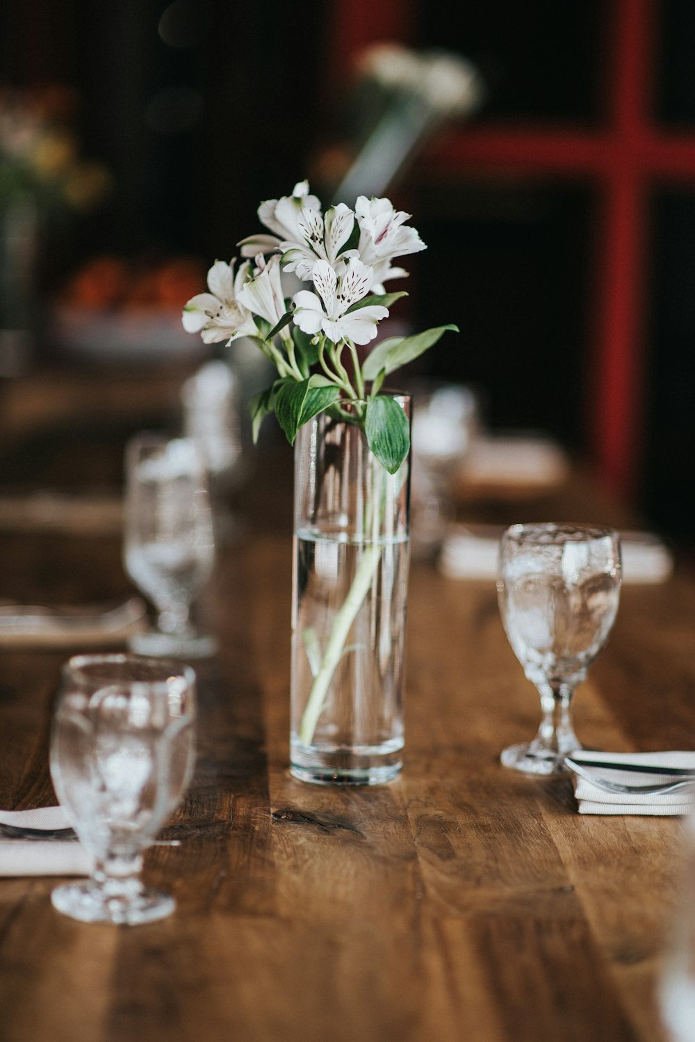 white flowers in clear glass vase on brown wooden table