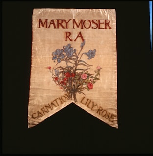 A decorative banner featuring the name Mary Moser with R A beneath it. Below the text, there is an artistic depiction of a floral arrangement featuring blue, pink, and red flowers. The banner has a pointed end with the words 'Carnation Lily Rose' at the bottom.