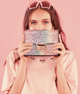 woman in pink long sleeve shirt holding brown and white cake