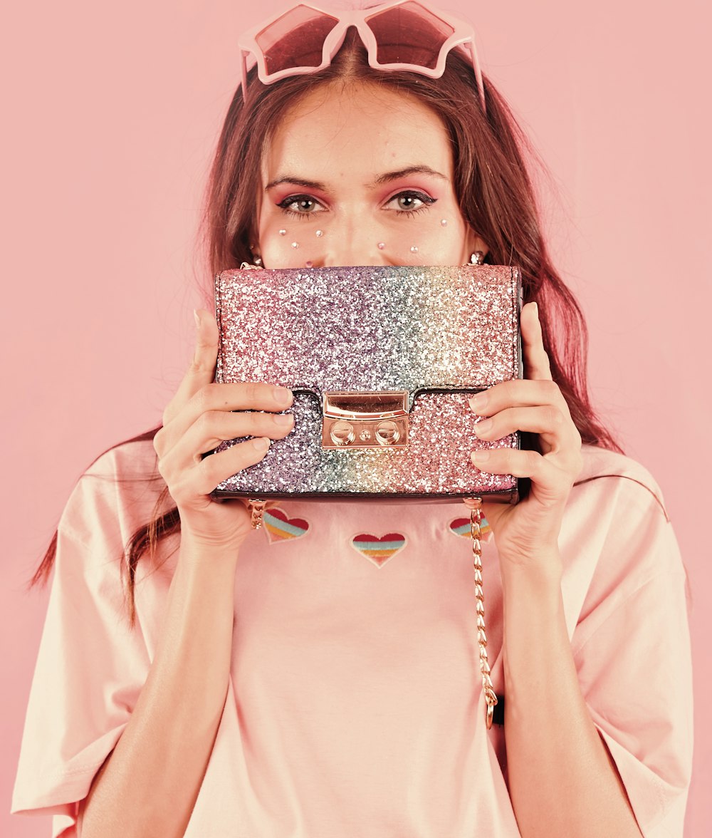 woman in pink long sleeve shirt holding brown and white cake