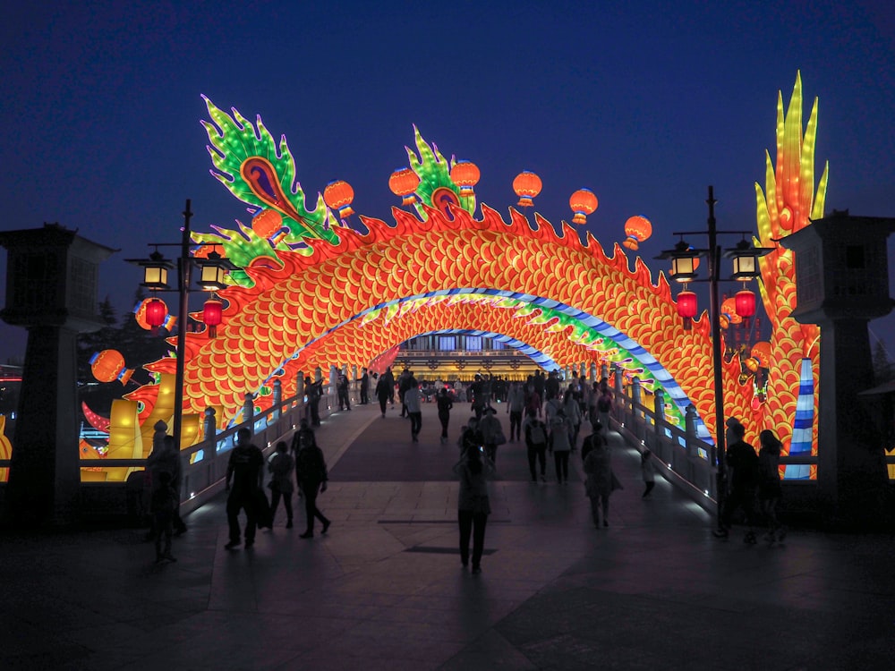 people walking on street with colorful lights during night time