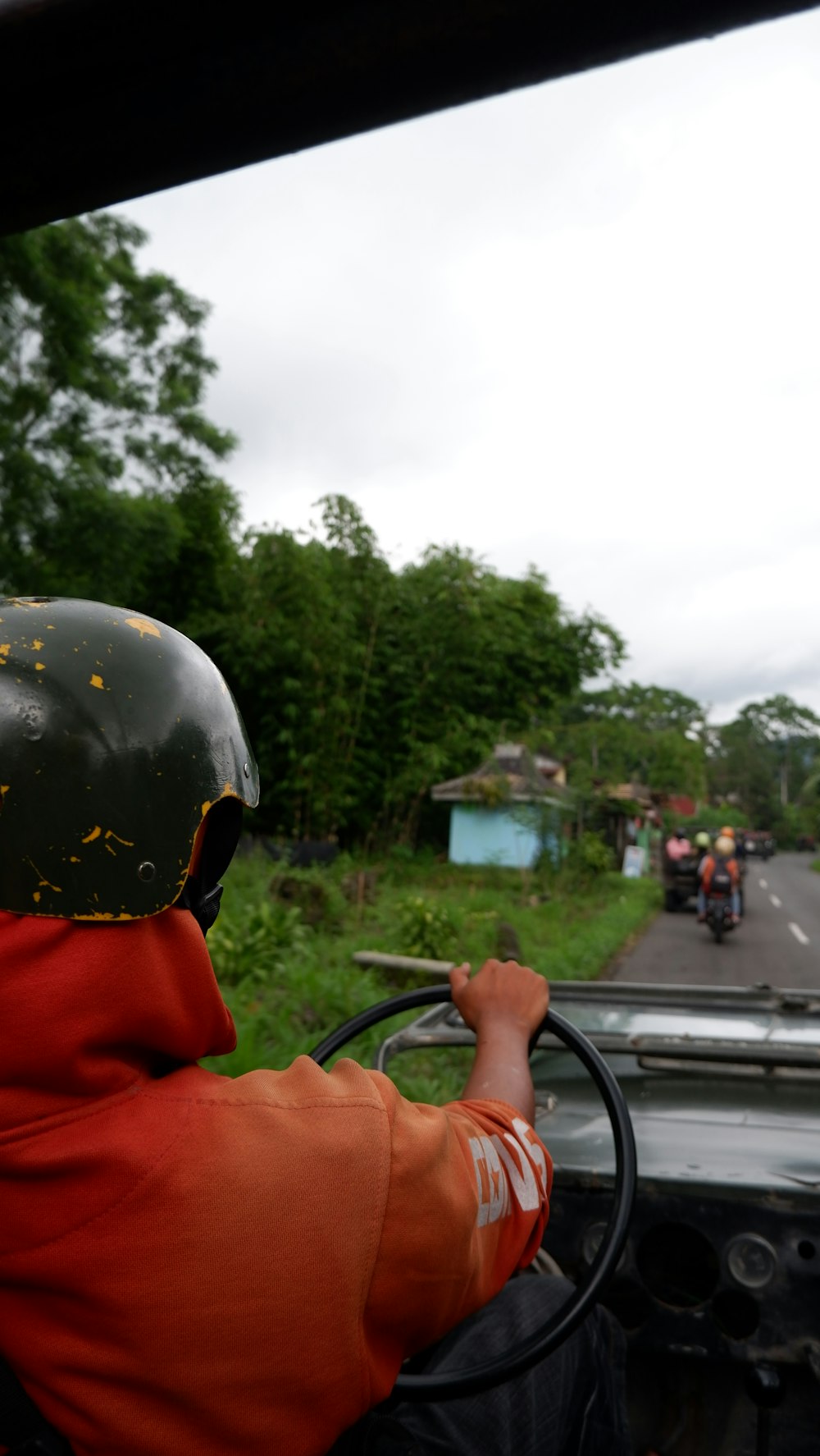 man in orange jacket wearing black helmet