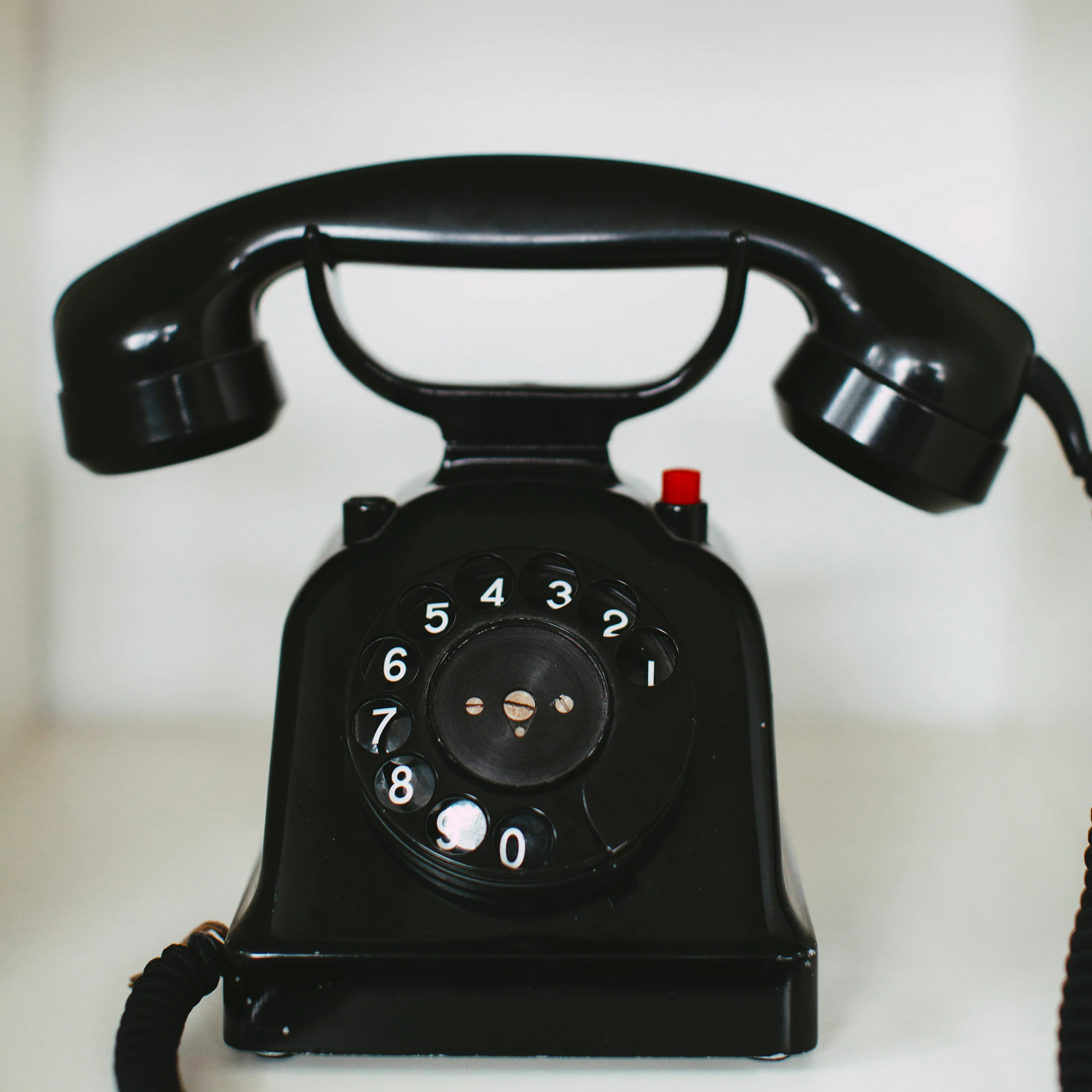 black rotary telephone on white table