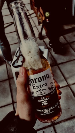 person holding clear glass bottle