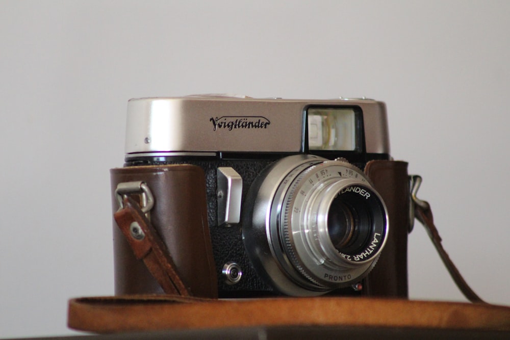 silver and black nikon camera on brown wooden table