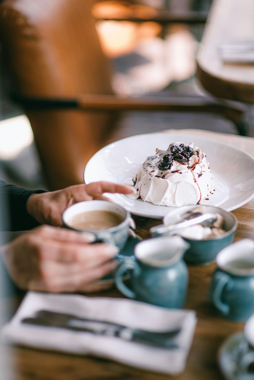 person holding white ceramic cup with ice cream