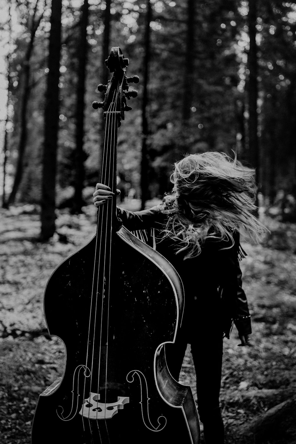 woman in black long sleeve dress playing guitar in grayscale photography