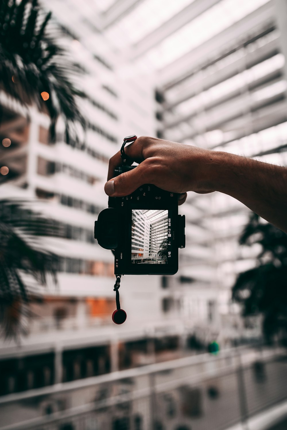 person holding black smartphone taking photo of building during daytime