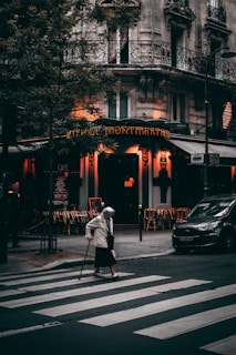 man in white jacket walking on pedestrian lane during daytime