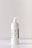 A white pump bottle labeled 'Vitamin Enriched Hand Sanitizer' with a green label bearing further text. The bottle sits on a plain white surface against a neutral background.