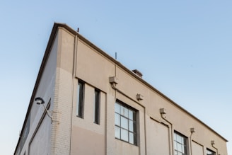 Exterior view of a spacious industrial building in Hungary with clear blue sky.