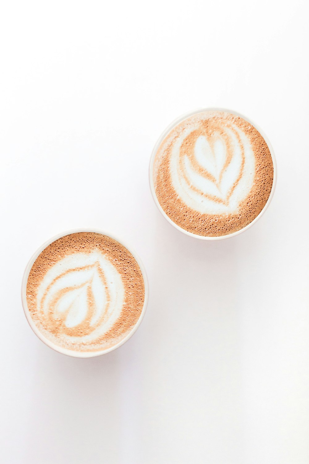brauner und weißer Cappuccino in Herzform