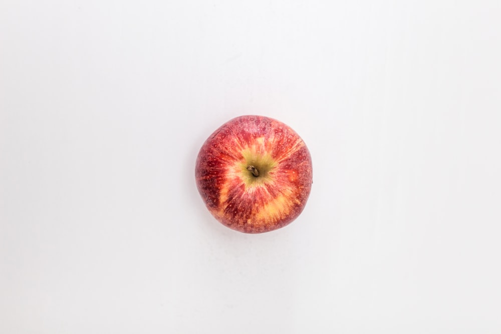 red apple fruit on white table