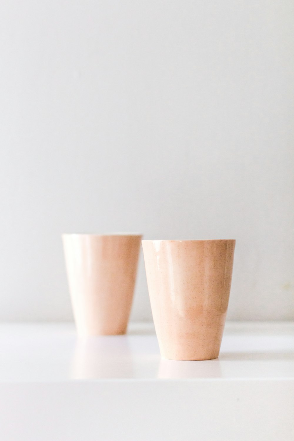 2 brown plastic cups on white table
