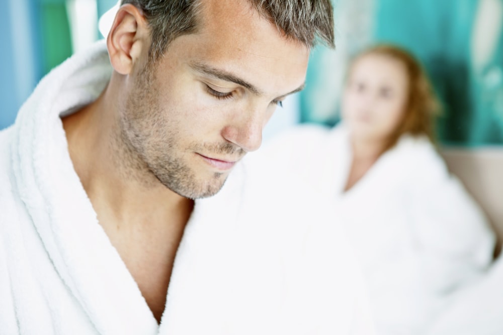 man in white robe beside woman in white shirt