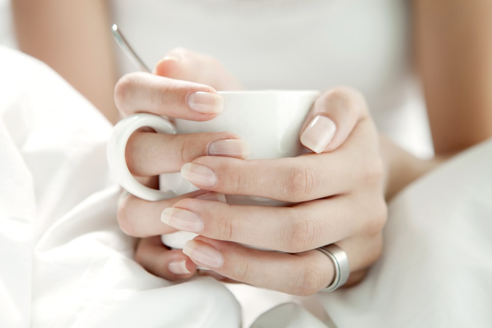 person holding white ceramic mug