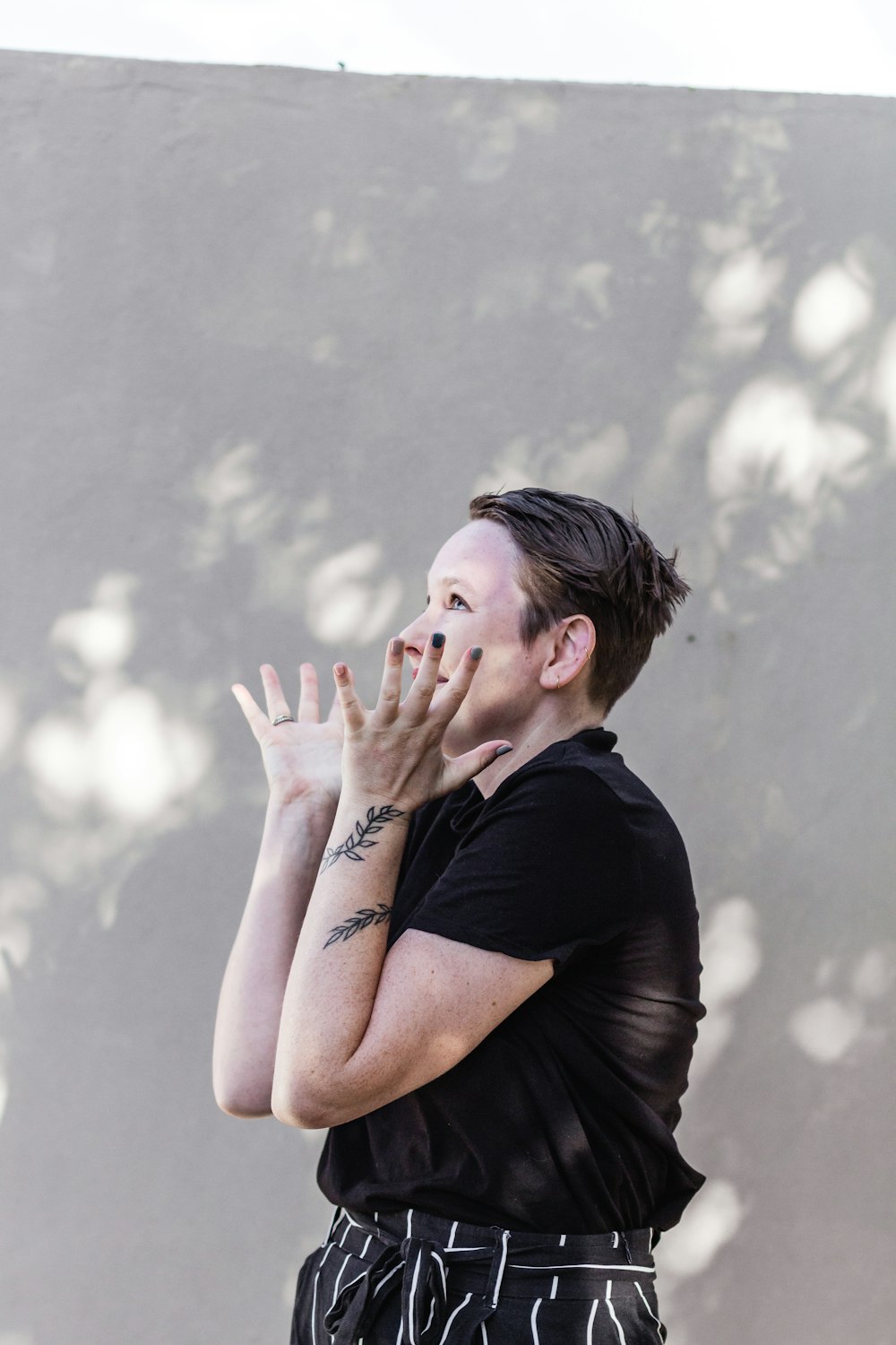 man in black crew neck t-shirt covering his face with his hand