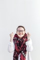 woman in white sweater wearing red scarf and black framed eyeglasses