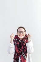 woman in white sweater wearing red scarf and black framed eyeglasses