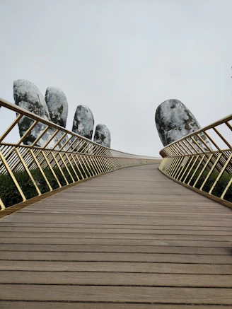 brown wooden bridge with gray concrete statue