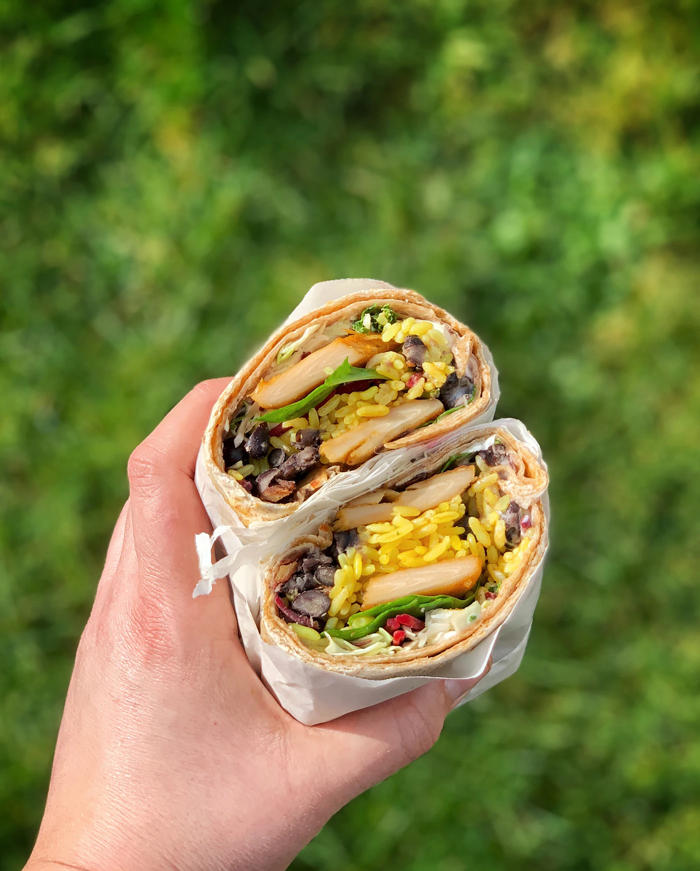 Wrap de pollo cortado por la mitad con verduras frescas
