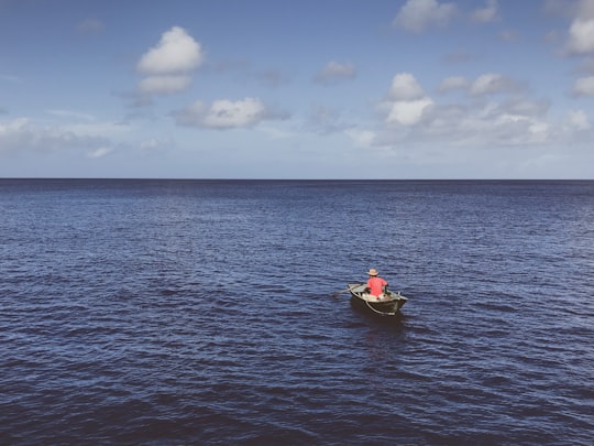 person in red kayak on sea under blue sky and white clouds during daytime in Itbayat Philippines