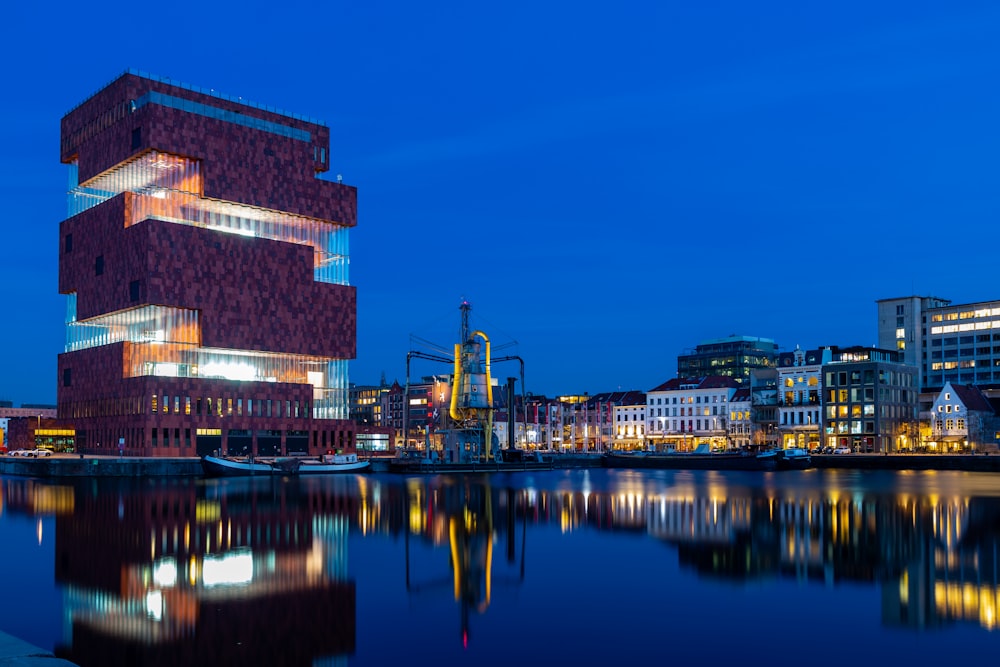 brown concrete building near body of water during night time