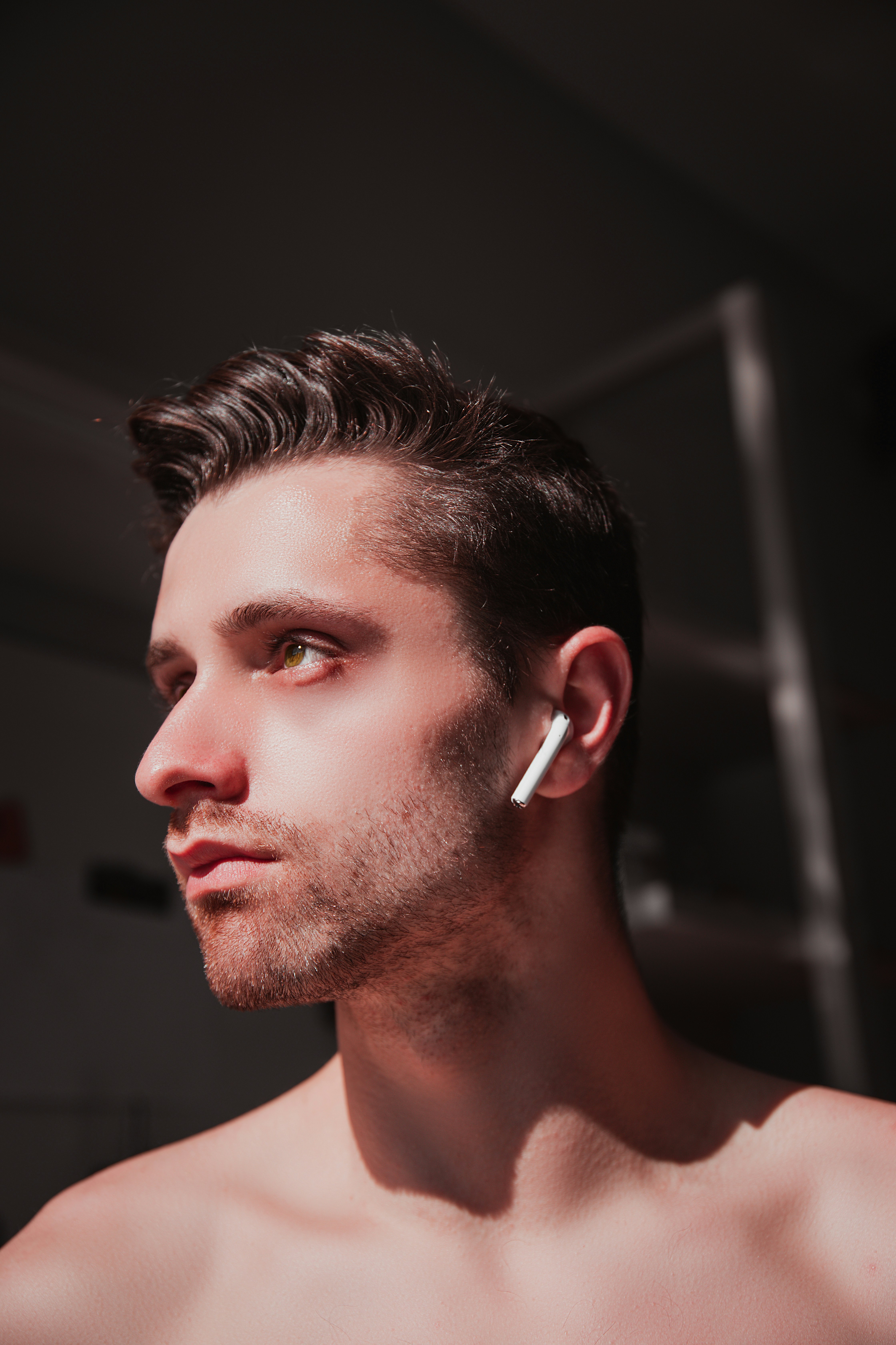 Man with earbuds looking away from camera