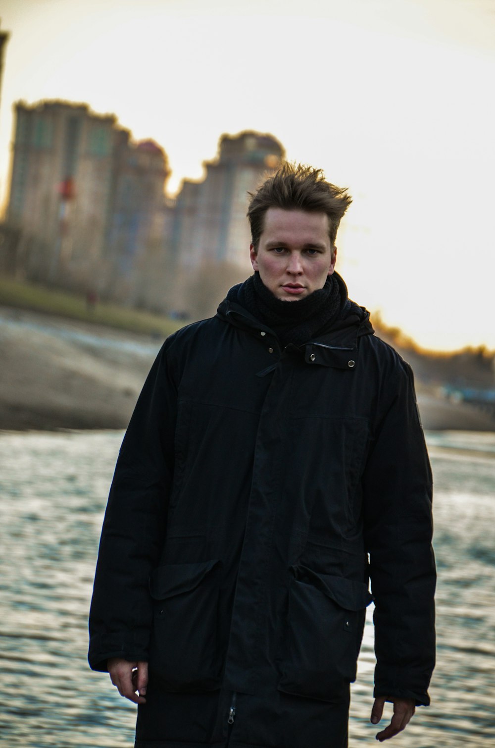 man in black jacket standing near body of water during daytime