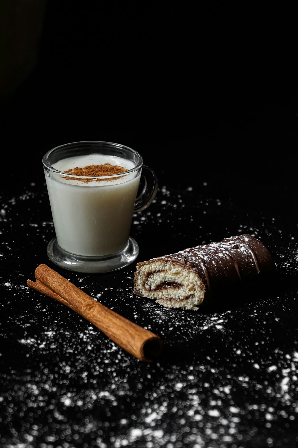 chocolate bar beside clear drinking glass with milk