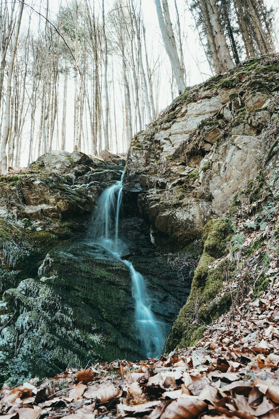 water falls in the middle of brown rocks