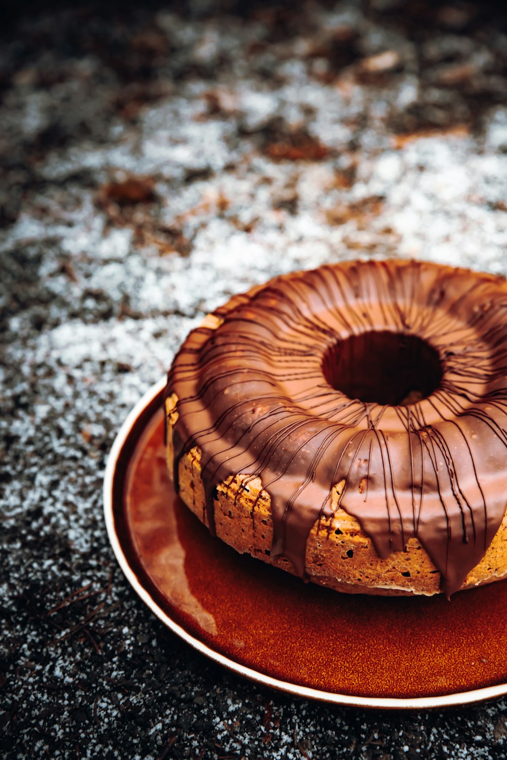 Gâteau rond brun sur assiette en céramique blanche