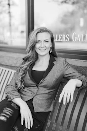 grayscale photo of woman in black blazer sitting on bench