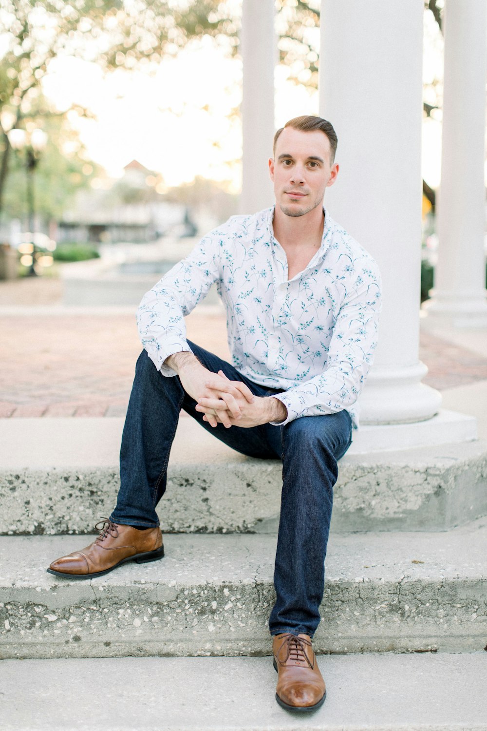 man in blue dress shirt and black pants sitting on concrete bench during daytime