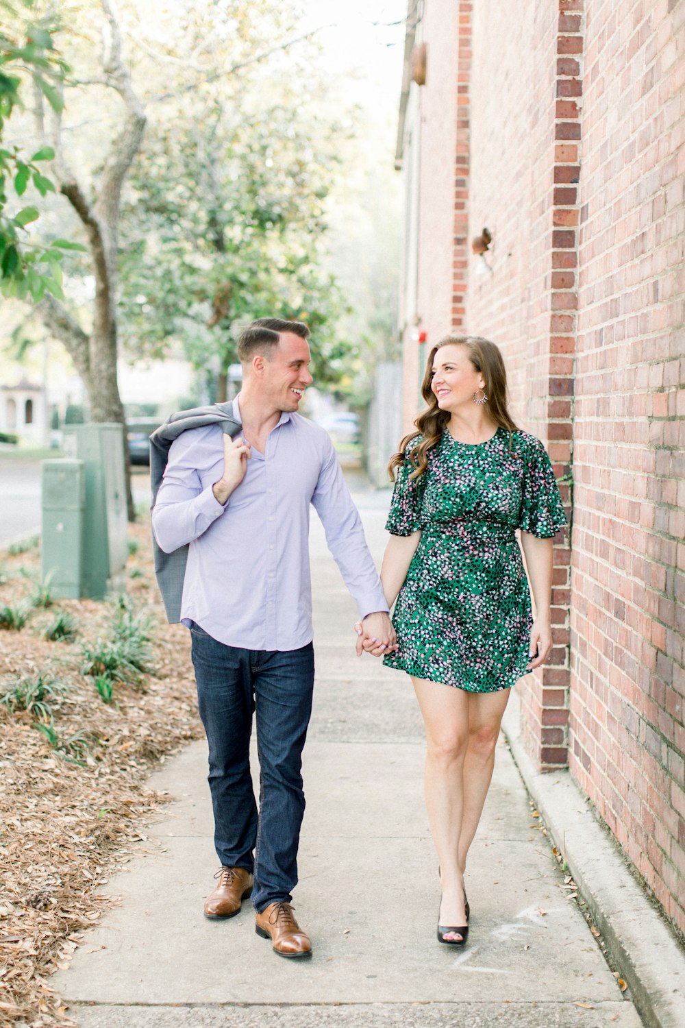 man and woman standing beside brick wall during daytime