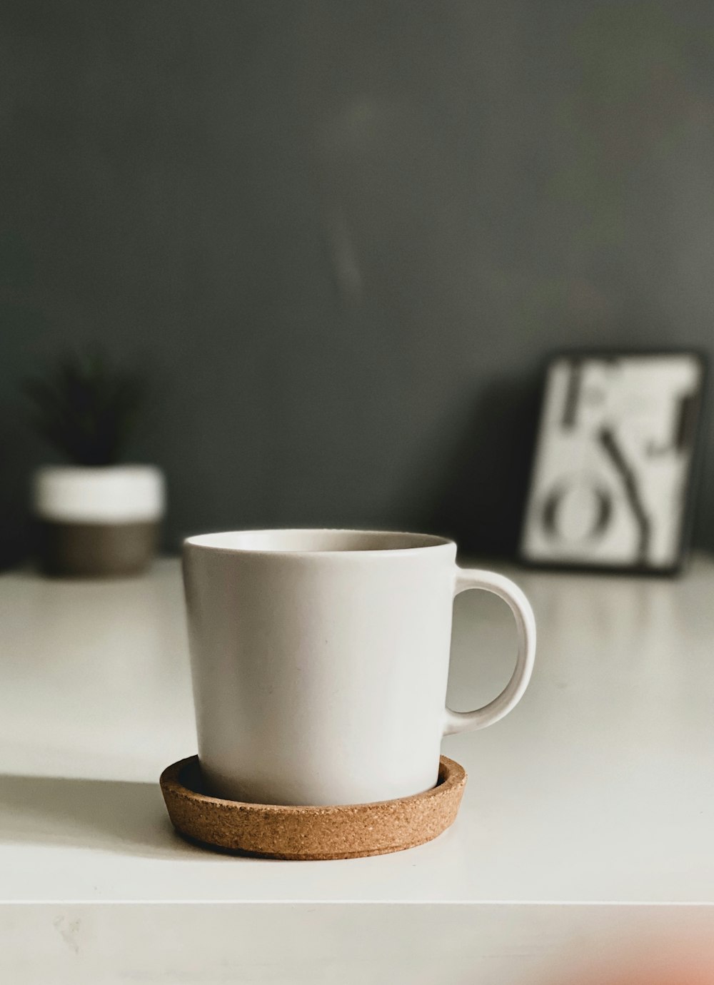white ceramic mug on brown coaster